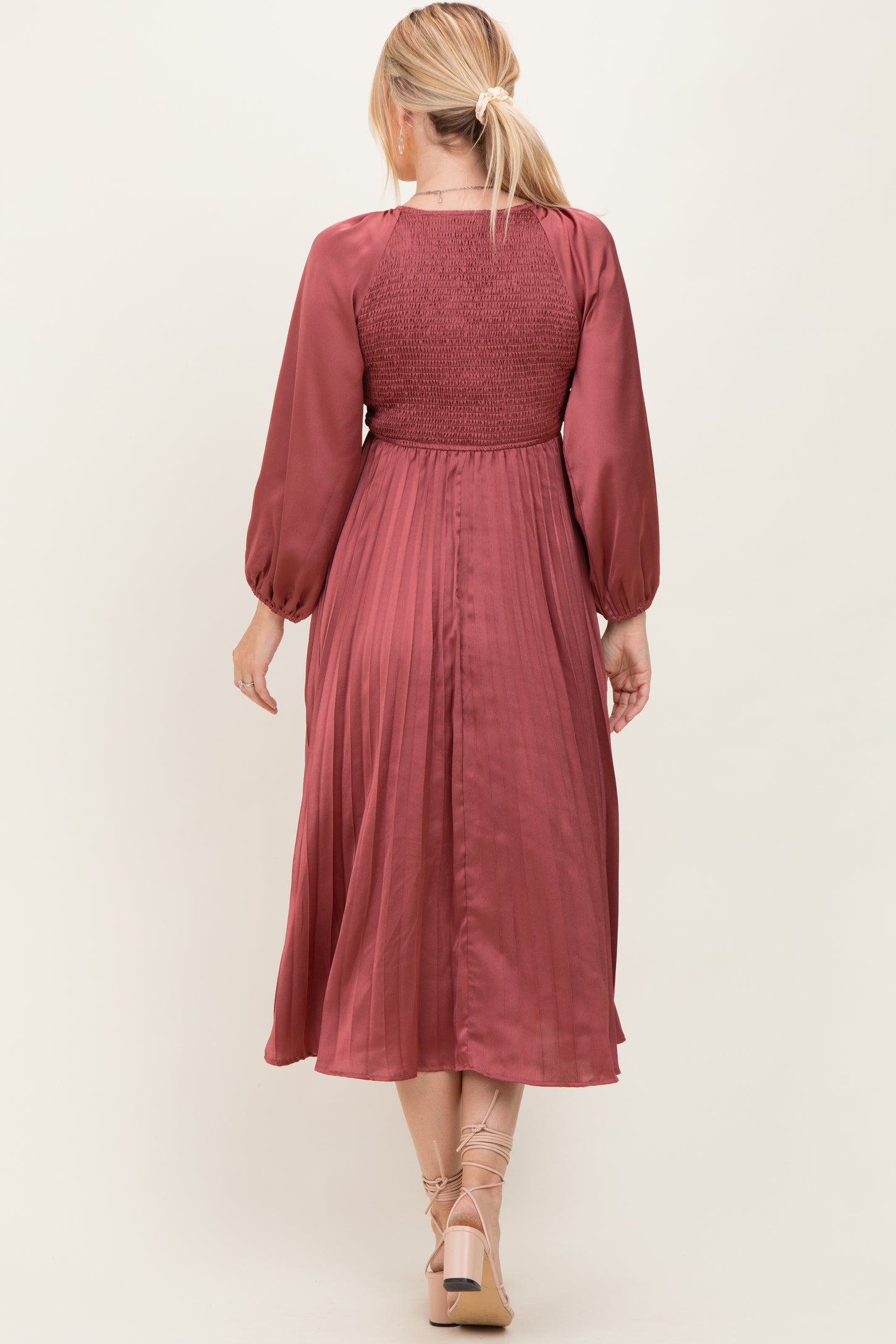 woman wearing a wine-colored midi dress with smocked bodice and long sleeves, shown from the back
