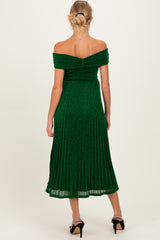 woman wearing an off-shoulder green maternity dress with a pleated design, showing a baby bump from the back