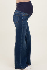 woman wearing dark wash maternity flared jeans with a navy belly panel covering her baby bump