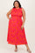 woman wearing a bright orange floral print plus size maxi dress with smocking and ruffled shoulders