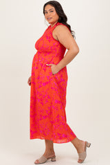 woman wearing a bright pink sleeveless plus size maxi dress with floral print and side pockets