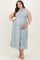 woman wearing a light blue floral sleeveless maternity dress and holding her baby bump