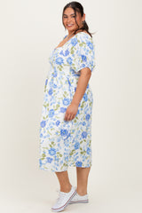 woman wearing a white floral plus size midi dress with blue flowers and puff sleeves, posing sideways