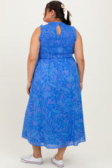 woman wearing a blue floral maxi dress with a keyhole back and smocked bodice, seen from the back