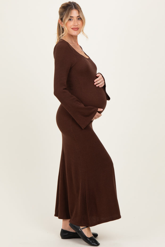 woman wearing a brown long sleeve maternity dress with flared sleeves and a visible baby bump