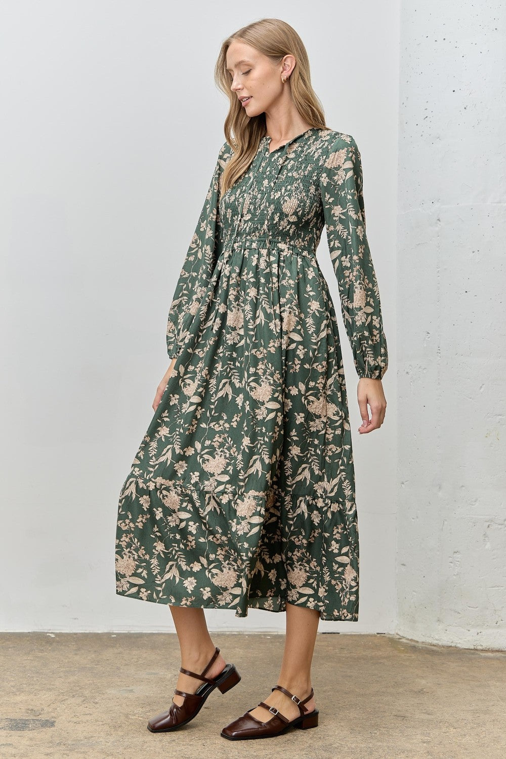 woman wearing a green floral long sleeve maxi dress and brown strappy shoes