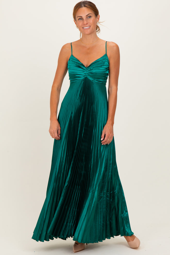 woman wearing a pleated emerald green maxi dress with a sweetheart neckline and adjustable spaghetti straps