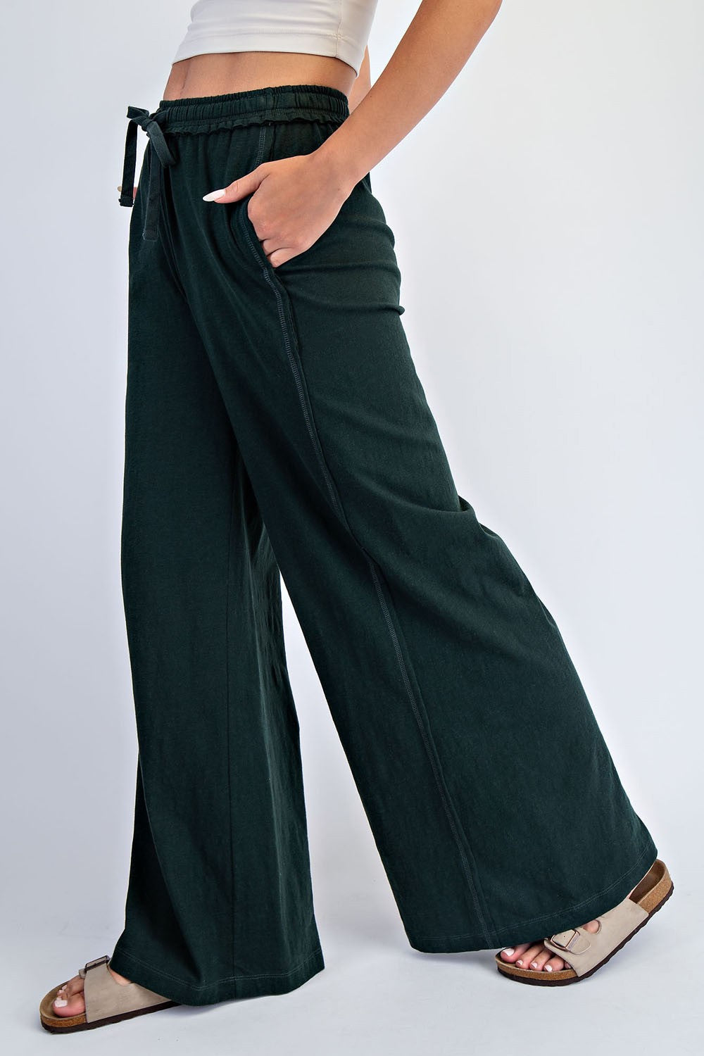 woman wearing black wide-leg lounge pants with pockets and a drawstring waist