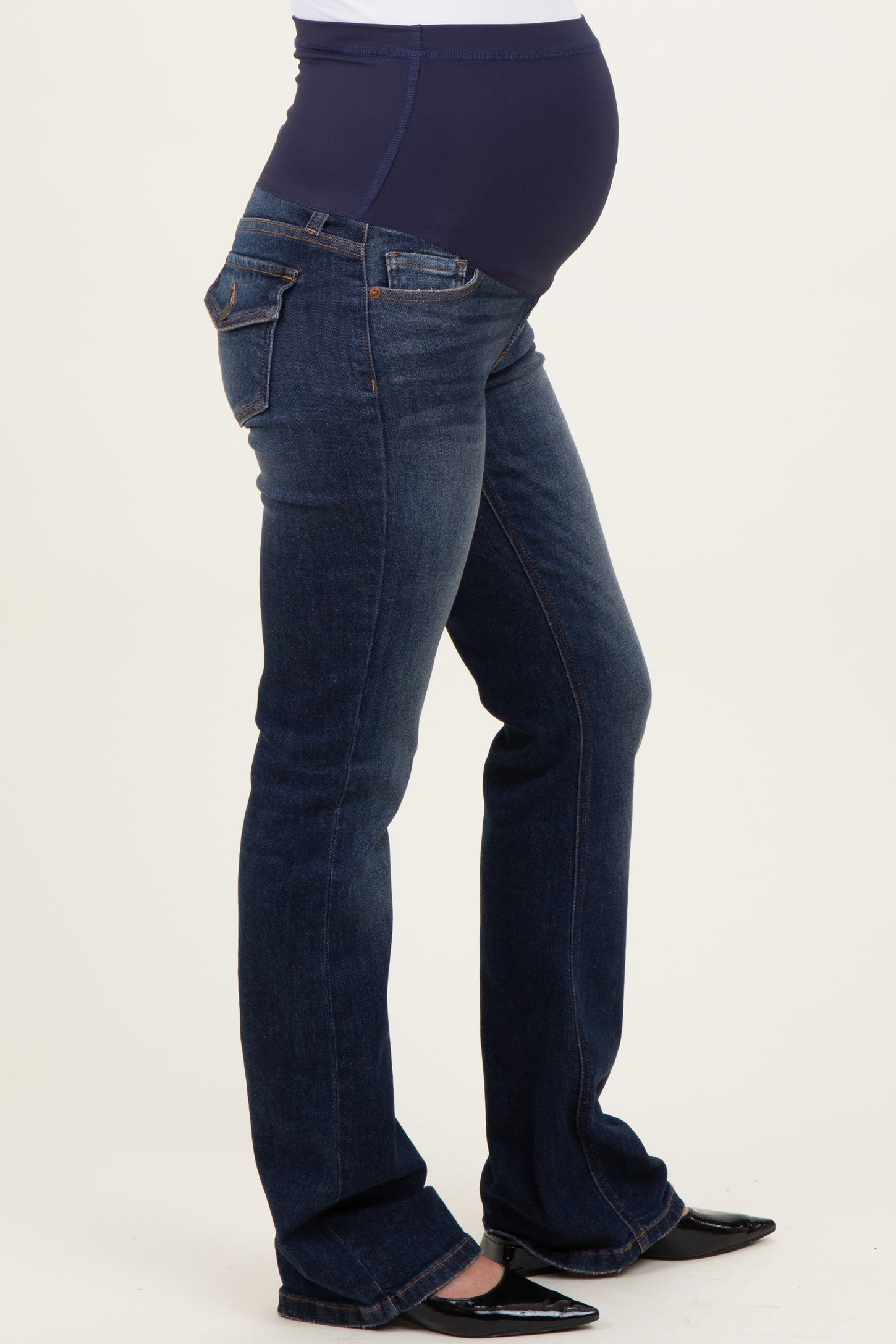 woman wearing dark blue maternity jeans with a high waistband and a visible baby bump
