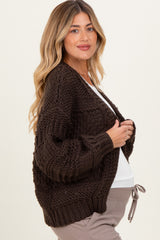 woman wearing a dark brown knitted maternity cardigan with a relaxed fit and visible baby bump