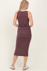 woman wearing a maroon and white striped sleeveless midi dress, showing the back view