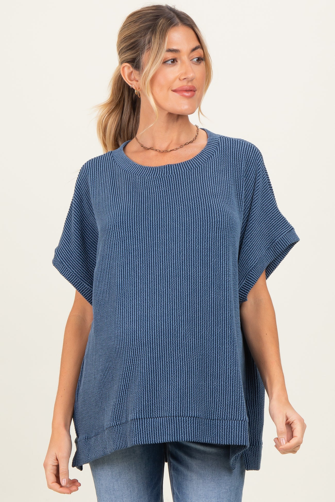 woman wearing a navy blue ribbed maternity top with short sleeves and a relaxed fit