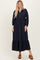 woman wearing a navy blue long sleeve button-up maxi dress with a tiered hem and puff sleeves