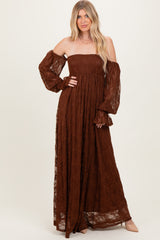 woman wearing a brown lace off-shoulder maxi dress with long puff sleeves