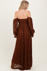 woman wearing a brown off-the-shoulder lace maxi dress with long puff sleeves and a fitted bodice