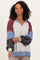 woman wearing a color block long sleeve sweater with a v-neck and puffed sleeves in gray, maroon, and blue