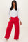 woman wearing a white long sleeve ribbed top and red wide-leg pants with side pockets and white detailing