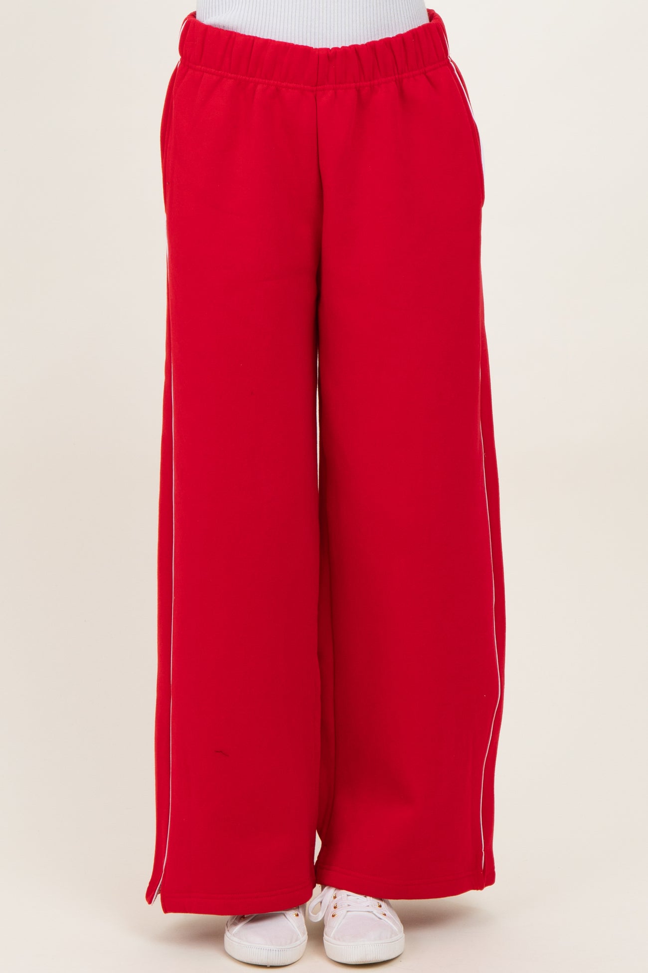 woman wearing red wide-leg sweatpants with white side stripes and an elastic waistband