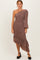 woman wearing a brown one-shoulder dress with ruching and a ruffled hem, styled with black heels