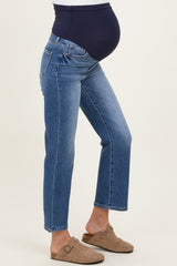 woman wearing blue maternity jeans with a supportive belly panel and a visible baby bump