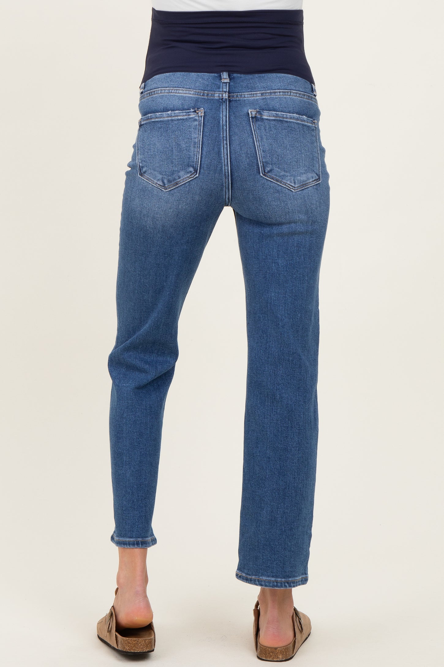 woman wearing a pair of blue maternity jeans with a soft navy waistband from the back