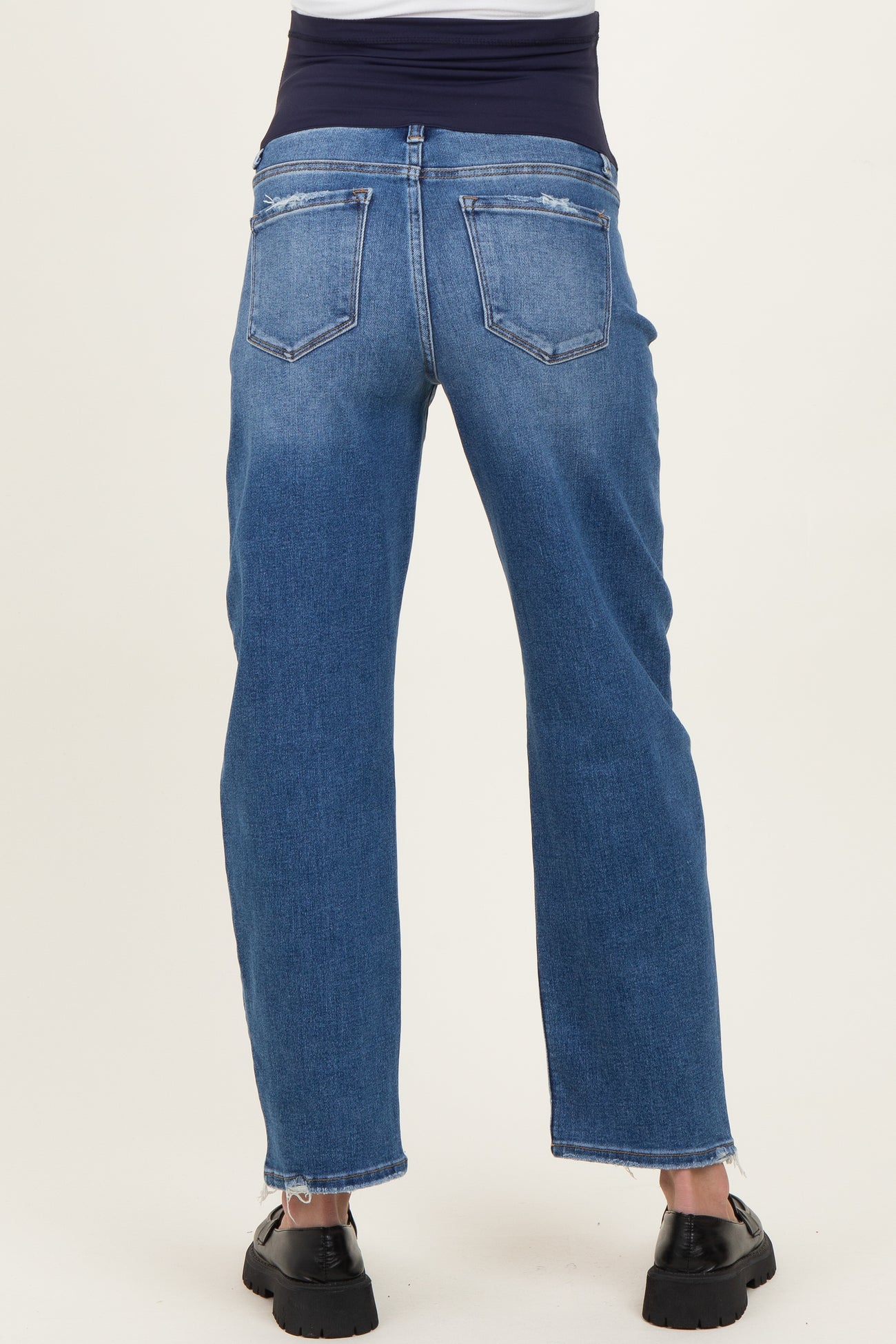 woman wearing blue maternity jeans with a stretchy waistband, viewed from the back
