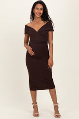 woman wearing a brown off-the-shoulder maternity dress with a fitted silhouette and holding her baby bump