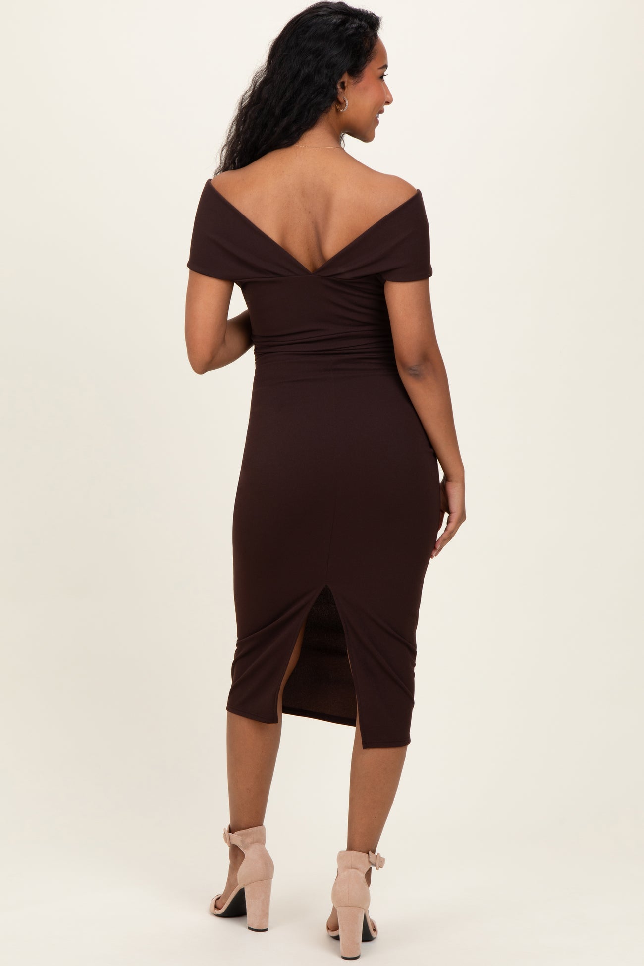 woman wearing a brown off-shoulder maternity dress with a fitted silhouette and a back slit