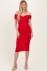 woman wearing a fitted red off-the-shoulder midi dress with a sweetheart neckline and a bodycon silhouette