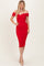 woman wearing a red off-the-shoulder fitted dress and nude heels, posing with one hand on her hip