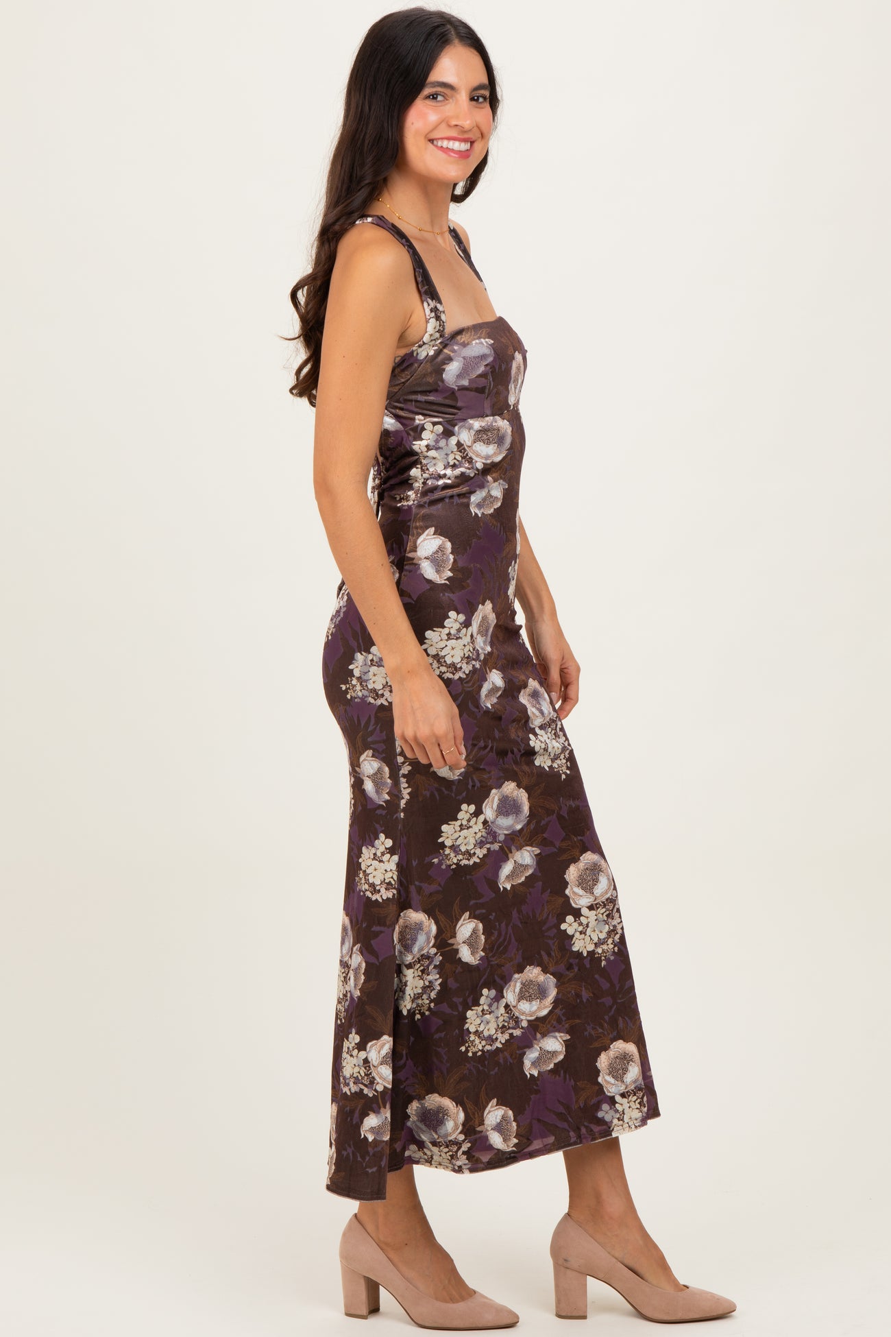 woman wearing a brown floral print maxi dress with spaghetti straps and a fitted silhouette