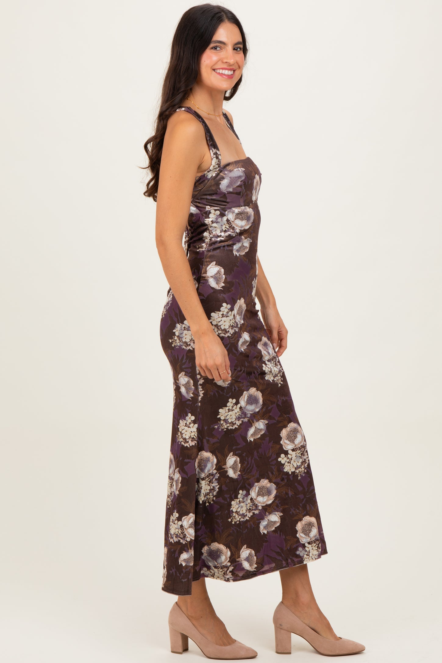 woman wearing a brown floral print maxi dress with spaghetti straps and a fitted silhouette