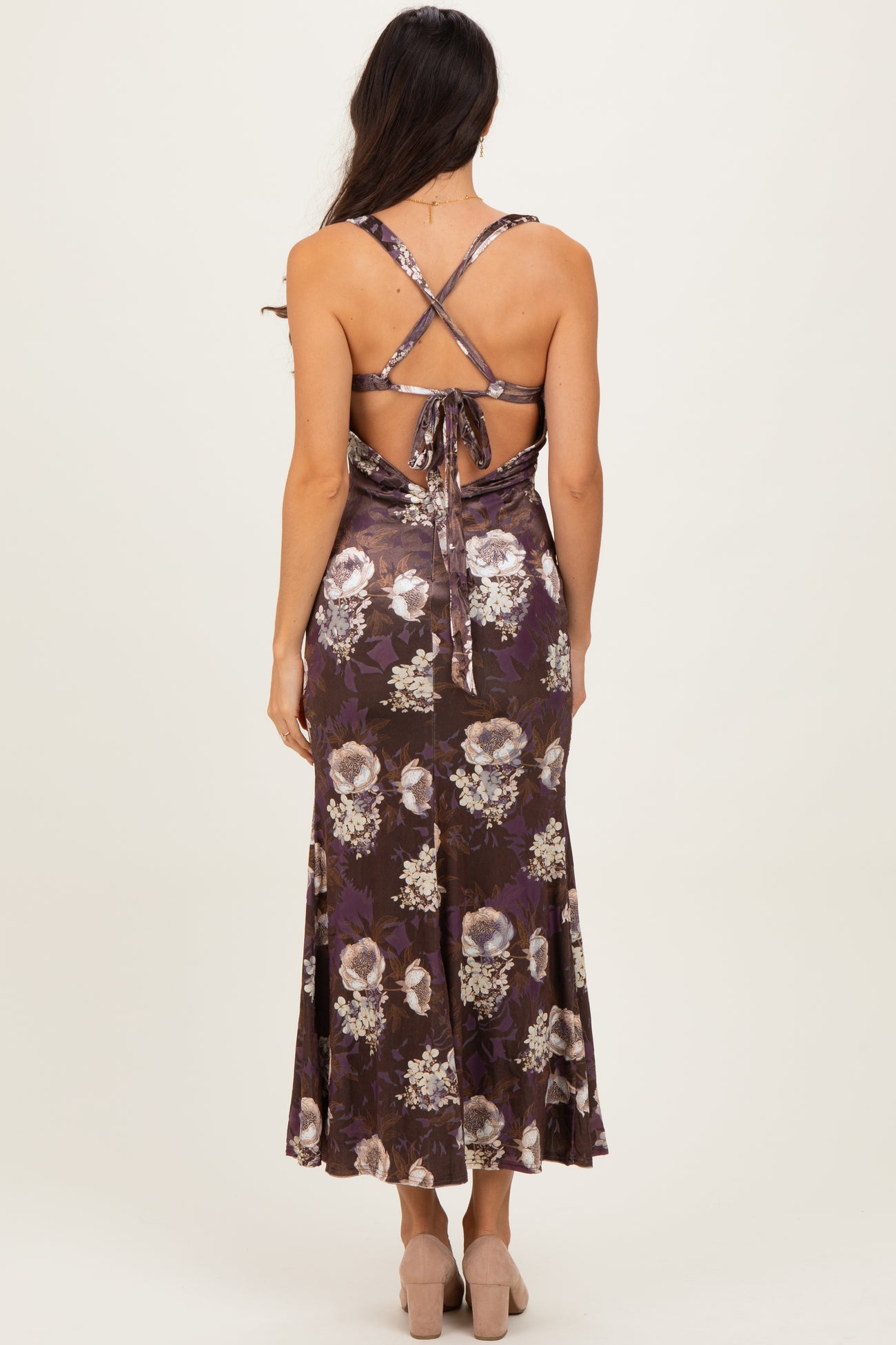 woman wearing a backless floral midi dress with a tie detail and spaghetti straps