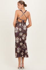 woman wearing a floral maternity dress with a fitted bodice and flared hem, showcasing a crisscross back design