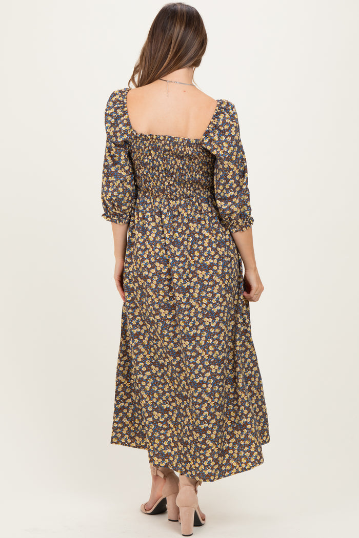 woman wearing a floral maternity maxi dress with smocked details and puff sleeves, showing a baby bump