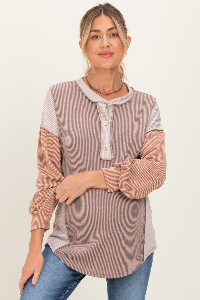 woman wearing a striped maternity top with button details and a relaxed fit, showcasing her baby bump