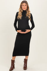woman wearing a black long sleeve maternity dress and holding her baby bump