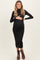 woman wearing a black long sleeve maternity dress, smiling and holding her baby bump