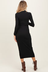 woman wearing a black long sleeve maternity dress with a form-fitting style, showing her back and mid-calf length