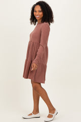 woman wearing a rust ribbed long sleeve dress with tiered layers and white flats