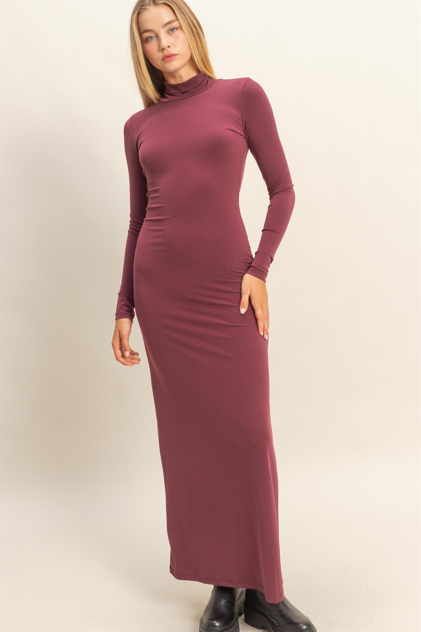 woman wearing a burgundy long sleeve turtleneck maxi dress with a fitted silhouette