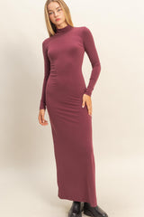woman wearing a burgundy long sleeve turtleneck maxi dress with a fitted silhouette