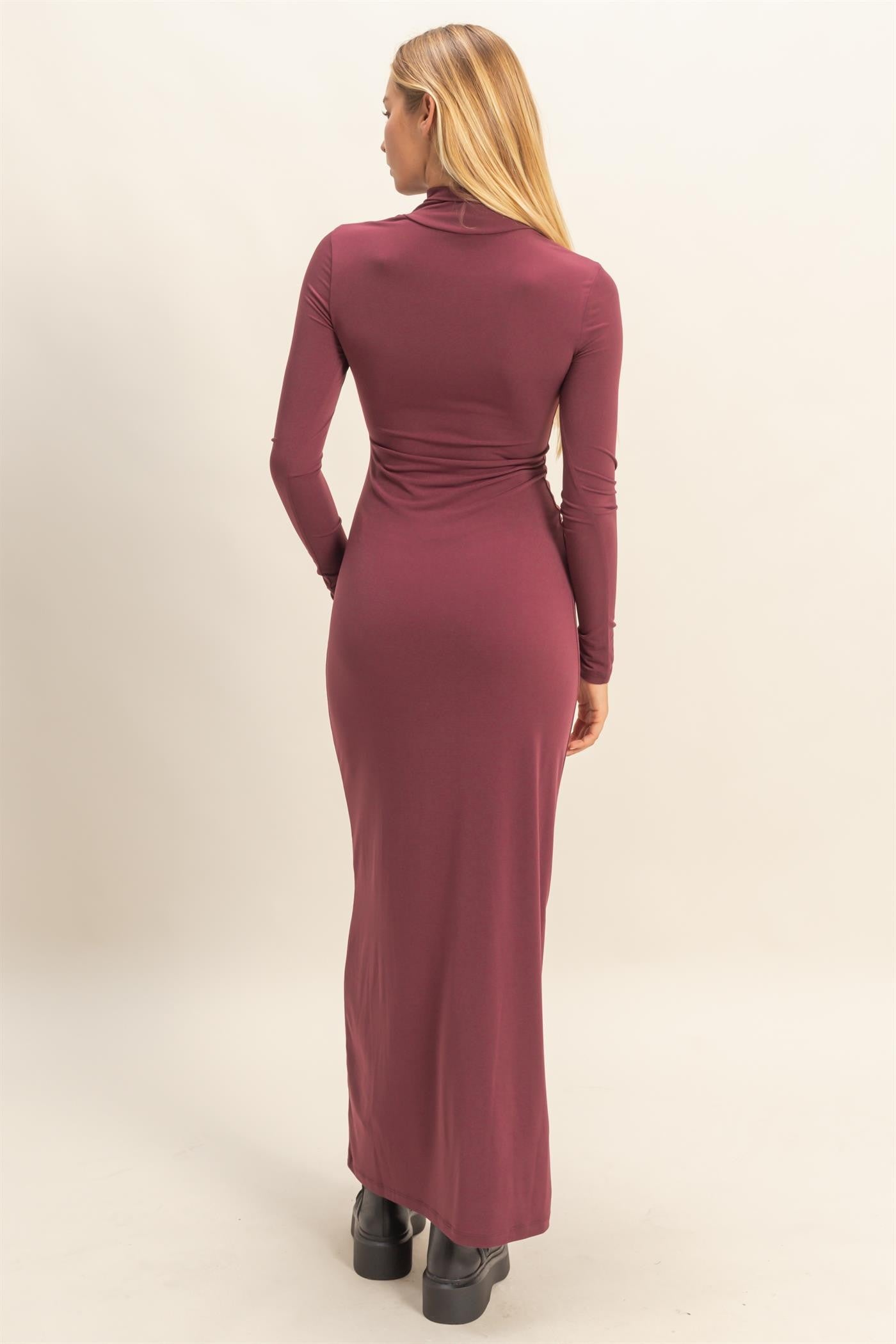 woman wearing a burgundy long sleeve bodycon maxi dress, showing the back view with a fitted silhouette