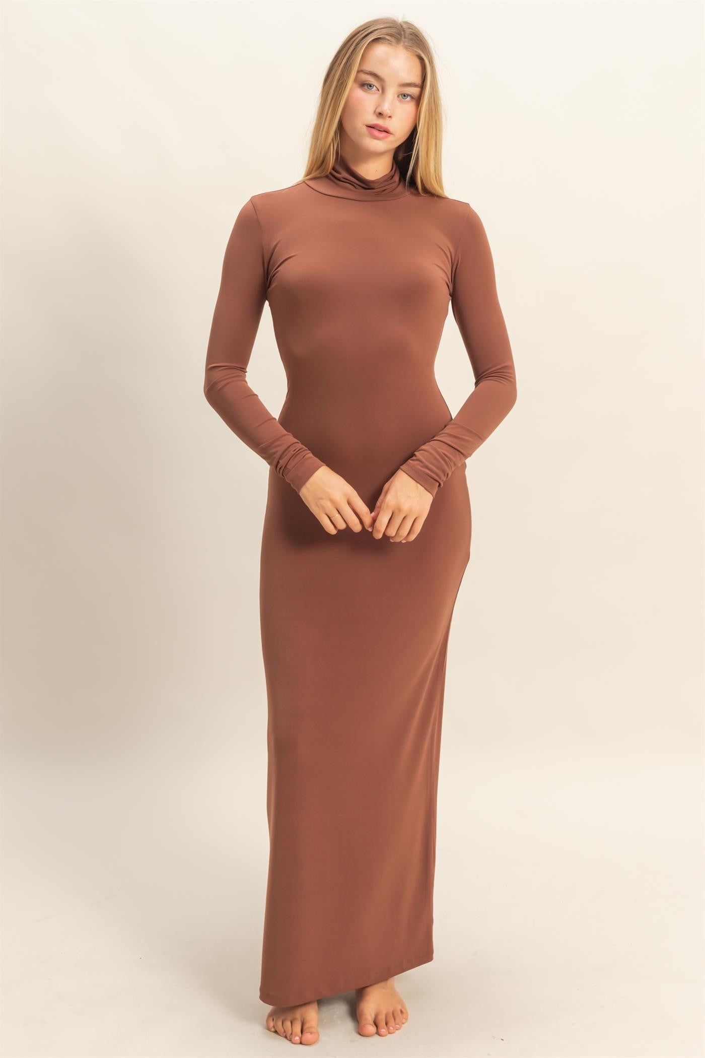 woman wearing a brown long sleeve maxi dress with a high neckline