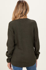 woman wearing a dark green maternity sweater with a textured pattern, showing the back view