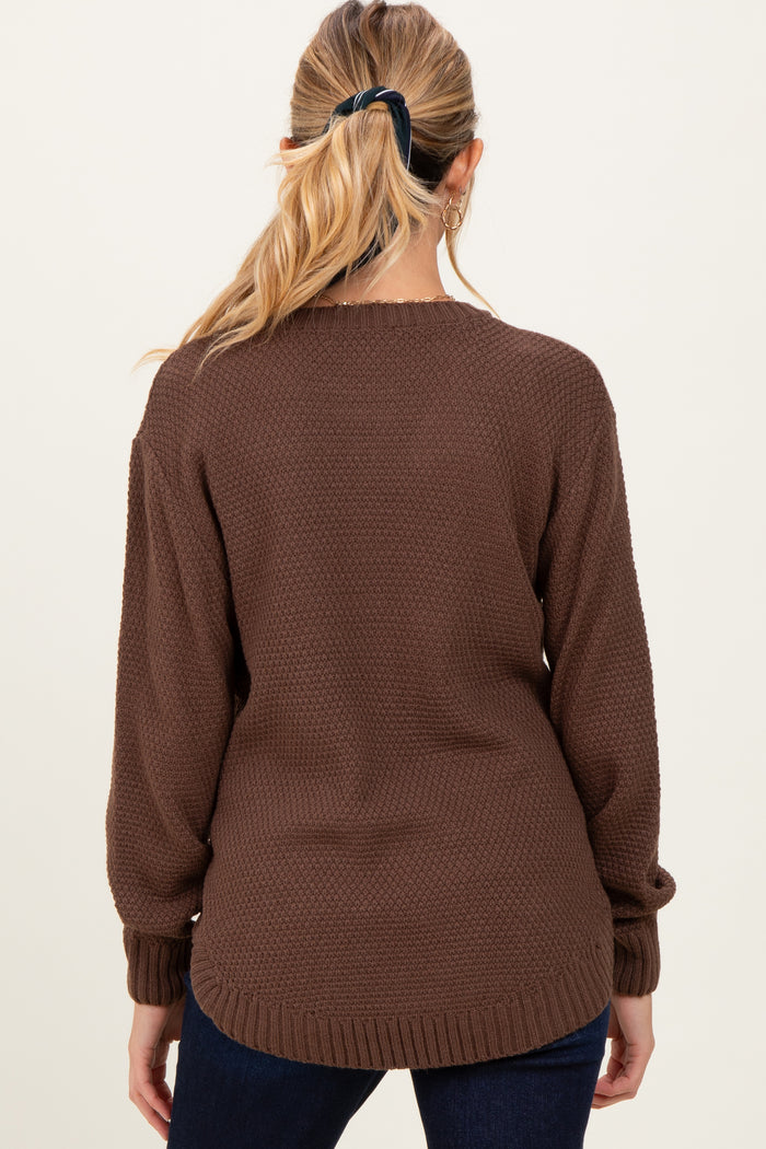 woman wearing a brown textured maternity sweater with long sleeves and a relaxed fit, seen from the back
