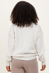 woman wearing a light gray oversized sweatshirt from the back, styled with loose-fit pants