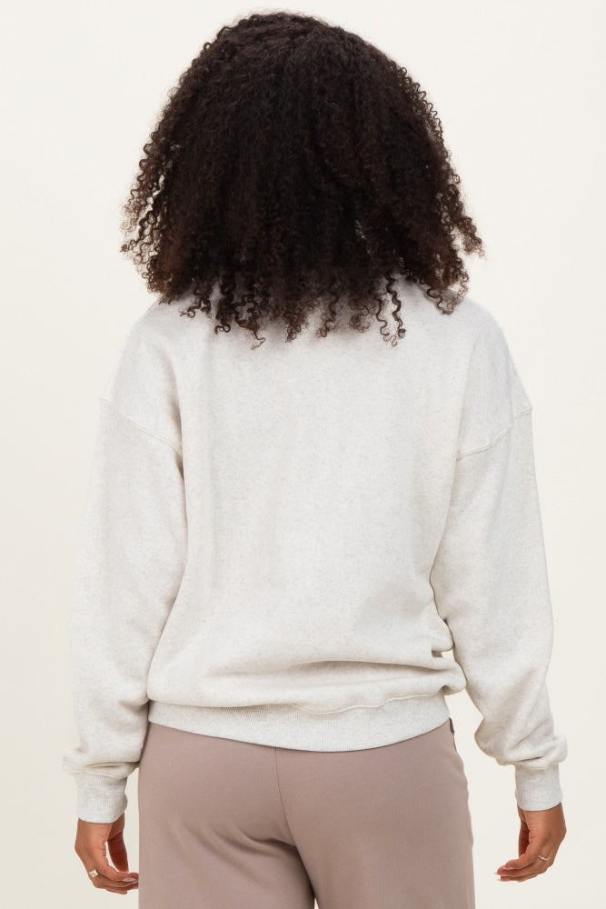 woman wearing a light gray oversized sweatshirt from the back, styled with loose-fit pants