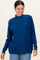 woman wearing a blue high neck sweater with a relaxed fit and long sleeves, smiling against a neutral background