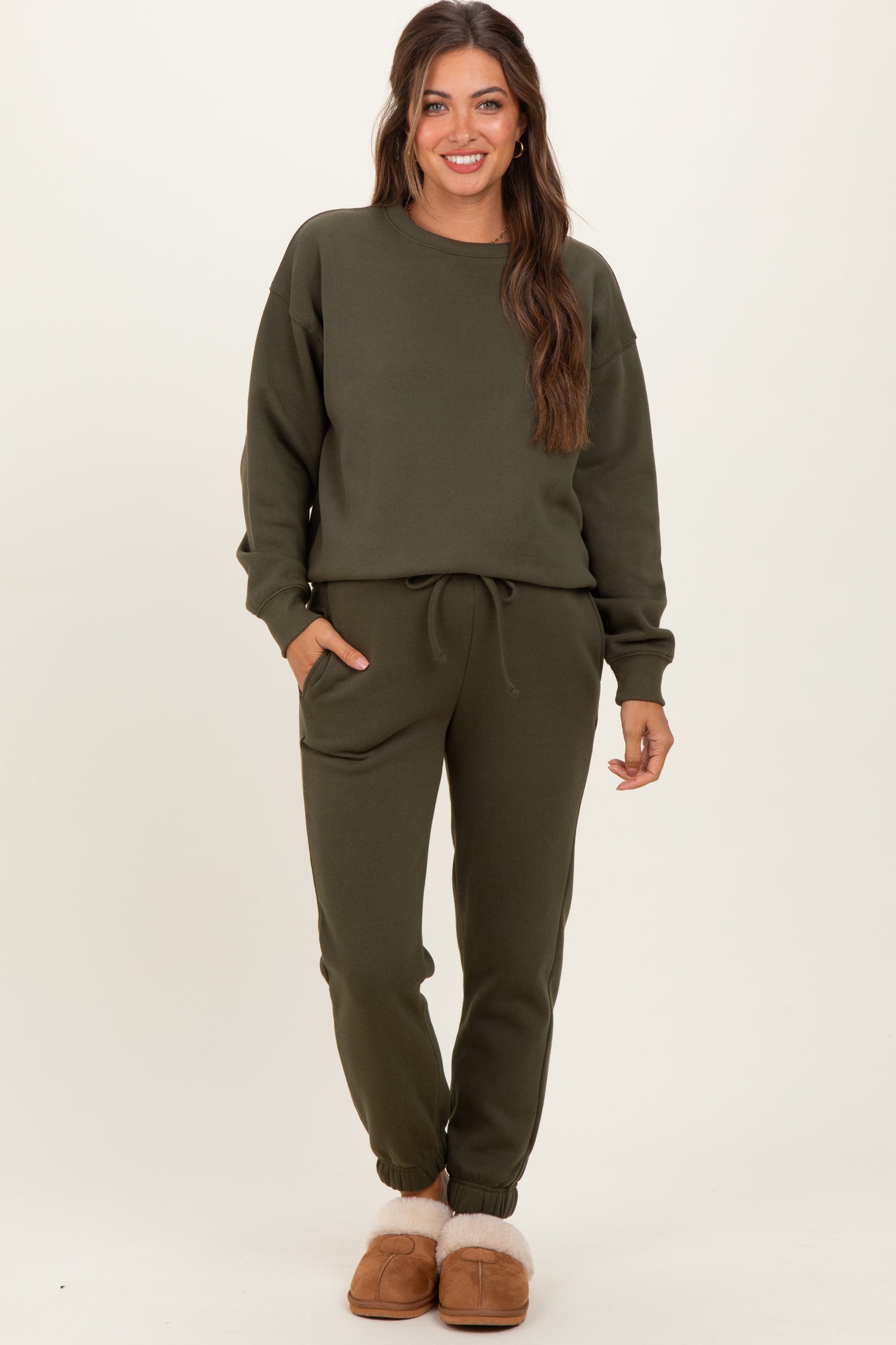 woman wearing a dark green maternity loungewear set with drawstring pants and long sleeve top, styled casually
